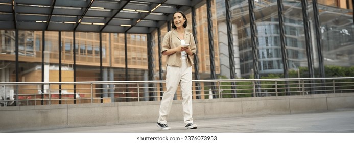 Portrait of asian female model with telephone. Young korean girl holding smartphone on street, using telephone. - Powered by Shutterstock