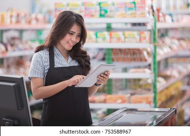 Portrait Of Asian Female Staff Standing In Front Of The Supermarket With Tablet Pc