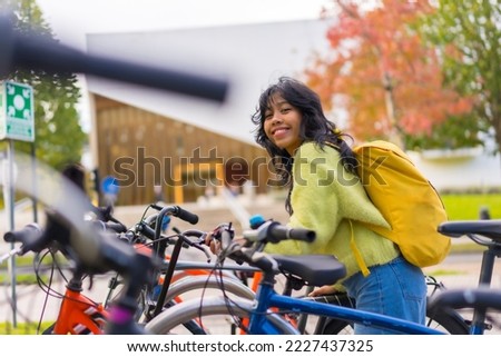 Portrait of asian female student parking the bike in college campus