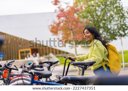 Portrait of asian female student parking the bike in college campus