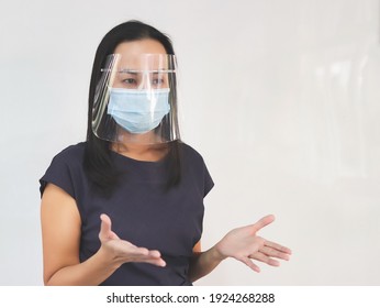 Portrait Of Asian Female Teacher Wearing Protective Face Mask And Face Shield,  Standing   At White Board In Front Of  Classroom,  Talking To The Student.  Covid19 Prevention And Education Concept.