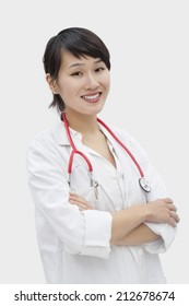 Portrait Of An Asian Female Veterinarian Standing Arms Crossed Over Gray Background