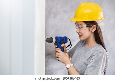 Portrait of asian girl with electric screwdriver home improvement and repair. Woman worker using tools building with drill. young technician diy concept - Powered by Shutterstock