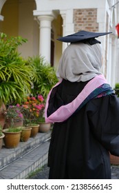 Portrait Of An Asian Girl With Hijab In Her Graduation Hat Holding Certificate And Not Looking At The Camera