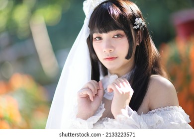 Portrait Of Asian Girl In Lolita Fashion Dress In Garden Background