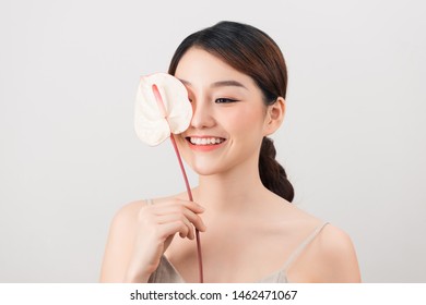Portrait of an Asian girl, one eye is covered with an anthuriums.