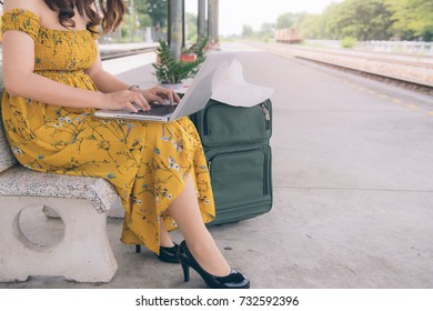 Portrait Of Asian Girl Texting On A Laptop In A Train Station While Is Waiting, Asia Woman With The Notebook On The Train Platform.