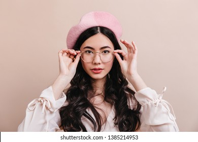 Portrait Of Asian Girl Touching Glasses. Front View Of Stylish Korean Model In French Beret.