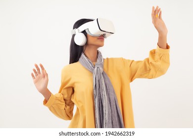 Portrait of Asian girl wearing virtual reality headset, touch the air, using hand gesture to control virtual online application, isolated on white background