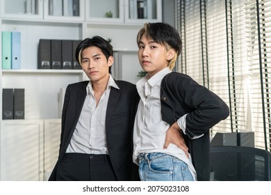 Portrait Of Asian Handsome Businessman Gay People Working In Office. Attractive Male Lgbtq Collegues In Formal Wear Standing With Gay Pride Happiness And Confidence At Workplace Then Looking At Camera