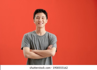 Portrait of Asian handsome man with arms crossed isolate on red background with copy space for text