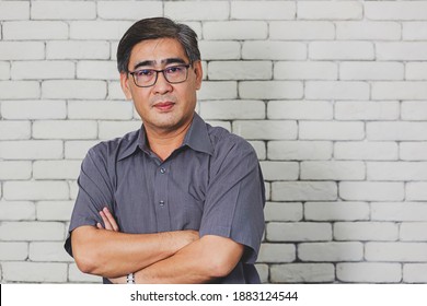 Portrait Of Asian Handsome Senior Elderly Man Wear Eyeglasses On White Brick Wall Background. Old Man Standing Golden Age Grandfather Healthcare Cheerful Lifestyle