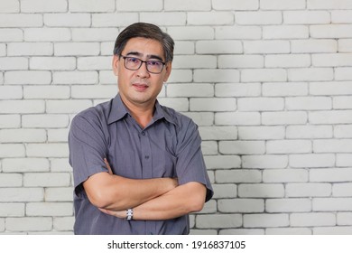 Portrait Of Asian Handsome Senior Elderly Man Wear Eyeglasses On White Brick Wall Background. Old Man Standing Golden Age Grandfather Healthcare Cheerful Lifestyle