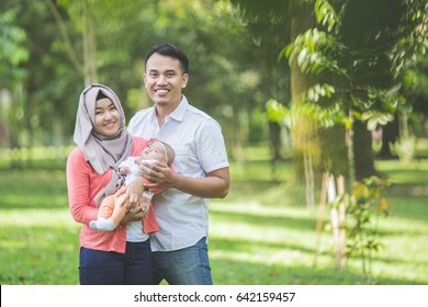 Portrait Of Asian Happy Family With Newborn Baby In The Park