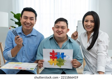 Portrait Of Asian Happy Family, Parents Draw Picture With Young Son. Beautiful Loving Couple, Mother And Father Take Care And Teach Young Man Painting Artwork Indoors And Looking At Camera In House.