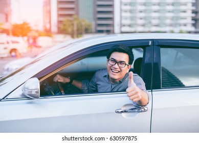 Portrait Of Asian Happy Handsome Man Showing Thumbs Up While Driving Car 