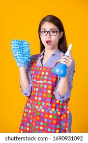 Portrait Asian Housekeeper Female Holding Dustpan And Cleaning Solution Bottle On Yellow Background