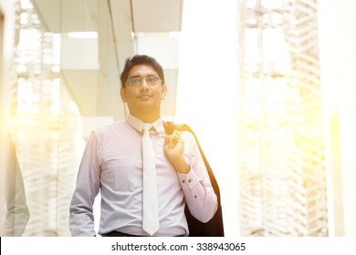 Portrait Of Asian Indian Business Man Walking Outside Modern Office Building Block, Beautiful Golden Sunlight At Background.