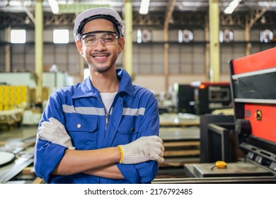 Portrait of Asian industrial worker man working in manufacturing plant. Young handsome male industry factory engineer wear helmet while processes product at manufactory warehouse and looking at camera - Shutterstock ID 2176792485