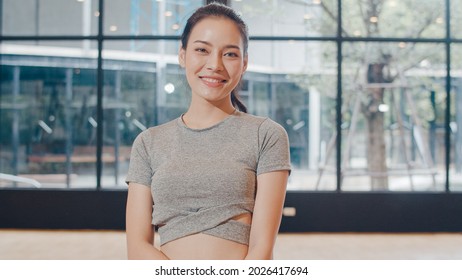 Portrait Asian japanese woman feeling happy fun at yoga class. Korean girl relax toothy smile looking to camera while exercising healthy lifestyle in fitness studio. Sport gymnastics activity.