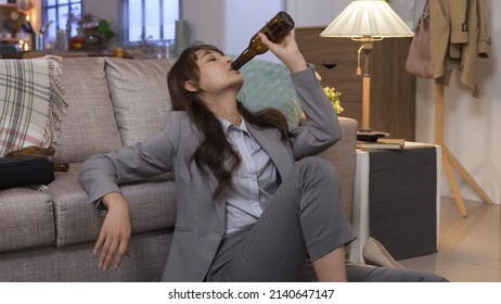 Portrait Asian Lady Gulping Wine In Depression At Home After Getting Layoff Information. Health And Alcohol Abuse Concept. Real Moments