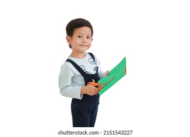 Portrait of Asian little boy craft work by scissors cut the color paper over white background.