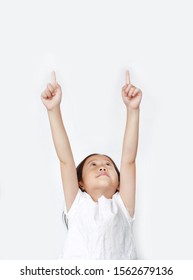 Portrait Of Asian Little Child Girl Pointing Two Forefinger Up And Looking Above Isolated Over White Background.