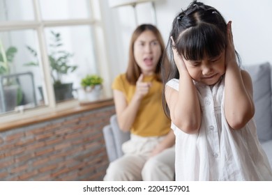 Portrait Of Asian Little Girl Close Her Ear While Angry Mother Yelling About Her Stubbon For Domestic Violence Concept