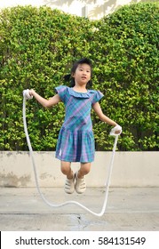 Portrait Of Asian Little Girl Jumping Handmade Rope Among Swing In The Park.selective Focus.