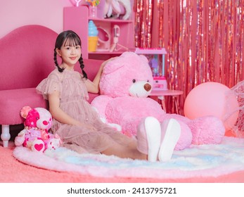 Portrait of Asian little girl wearing party dress in girly pink room. Photo studio. Memorial photo.