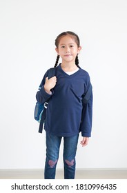 Portrait asian little kid girl in casual school uniform with backpack on white background. Studio shot