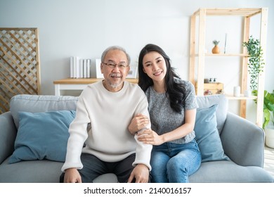 Portrait Of Asian Lovely Family, Daughter Hugging And Sit With Father. Attractive Woman Granddaughter Visit Senior Elder Mature Man In House Enjoy Spend Leisure Time Together Smile And Look At Camera.