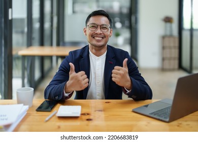 Portrait Of An Asian Male Business Owner Standing With A Computer Showing Happiness After A Successful Investment.