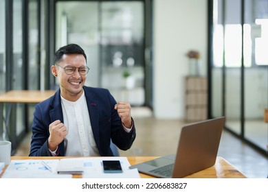 Portrait Of An Asian Male Business Owner Standing With A Computer Showing Happiness After A Successful Investment.