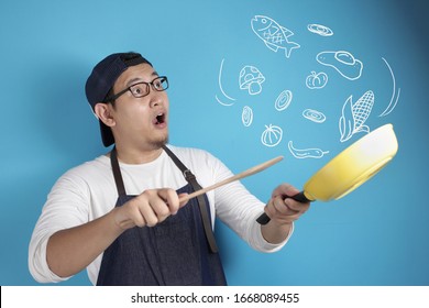 Portrait Of Asian Male Chef Smiling Happy While Holding Kitchen Tools, Chef Holding Spatula And Pan, Cooking Food Doodle , Against Blue Background