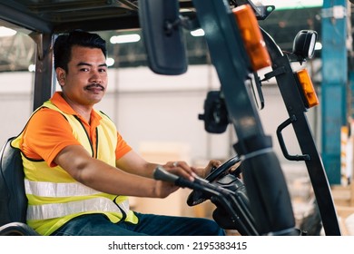 Portrait Of Asian Male Driver Driving Forklift To Shipping Delivery In The Warehouse Distribution. Import Export Logistic Career, Worker Working At Industrial Factory.