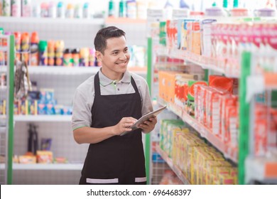 Portrait of asian male staff checking the product with tablet pc - Powered by Shutterstock