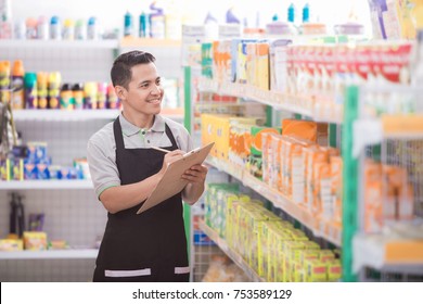 Portrait Of Asian Male Staff Checking The Product In Supermarket