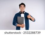 Portrait of Asian male student wearing cable and headphones , using laptop and  posing on white background