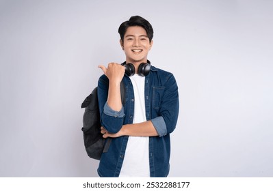 Portrait of Asian male student wearing cable and headphones posing on white background - Powered by Shutterstock