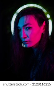 Portrait Of An Asian Man Against The Background Of A Circular Lamp In The Studio With Neon Light. 