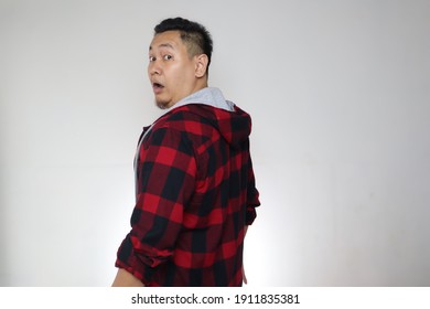 Portrait of Asian man looking behind his back over shoulder with shocked surprised expression