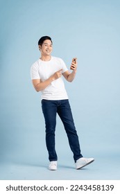 portrait of asian man posing on blue background - Shutterstock ID 2243458139