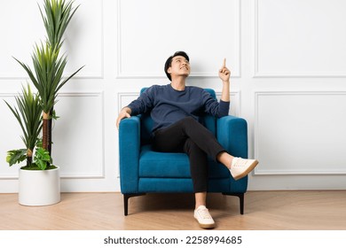 portrait of asian man sitting on sofa at home - Powered by Shutterstock