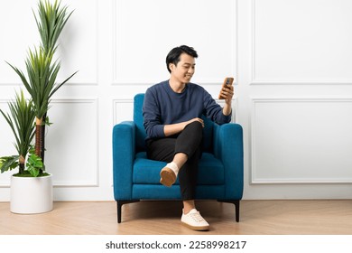 portrait of asian man sitting on sofa at home - Powered by Shutterstock