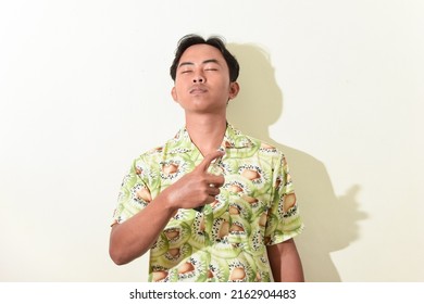 Portrait Of Asian Man Spraying Perfume On His Body. Indonesian Man In Hawaiian Shirt On White Background Isolated. Cool And Handsome Asian Man Portrait