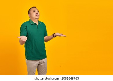 Portrait Of Asian Man Surprised With Confused And Displeased Expression On Yellow Background