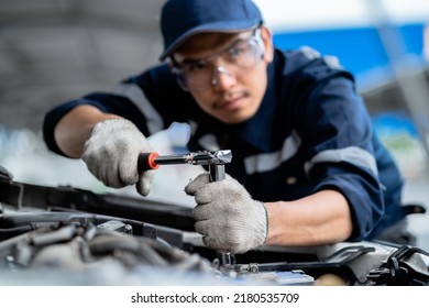 Portrait Of An Asian Mechanic With Repair Equipment Standing Confidently In A Car Repair Shop. Auto Mechanic In The Service Center. Car Safety Inspection. Repair Service Concept. Hand Focus