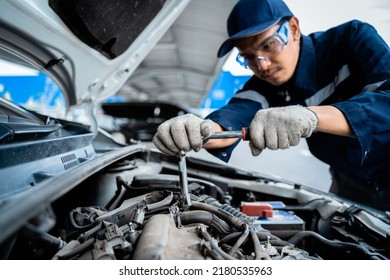 Portrait Of An Asian Mechanic With Repair Equipment Standing Confidently In A Car Repair Shop. Auto Mechanic In The Service Center. Car Safety Inspection. Repair Service Concept. Hand Focus