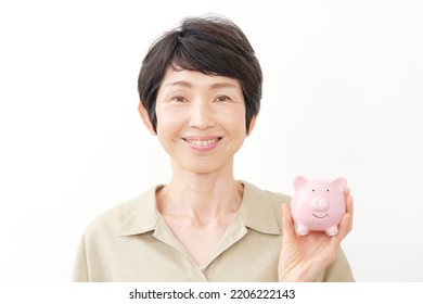 Portrait Of Asian Middle Aged Woman With The Piggy Bank In White Background